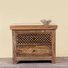 Hand carved mango wood nightstand with two drawers and hidden compartment in rustic artisan style.