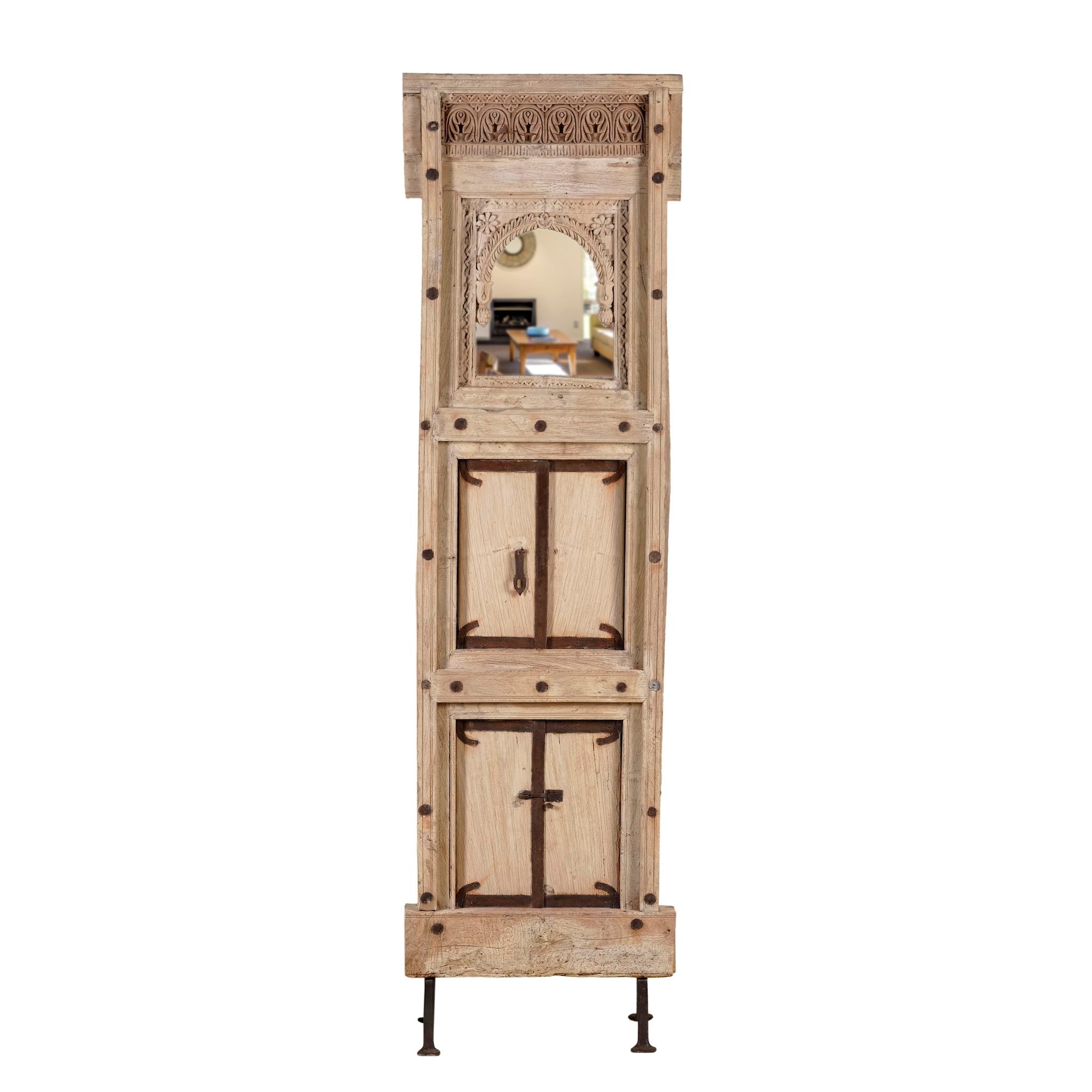 White background image of a unique Indian mirror stand Neha made from recycled teak wood with carved panels and iron base. A multifunctional boho wall decor piece combining storage and sustainable design.