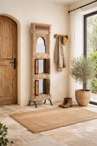 Lifestyle imagination of a unique Indian mirror stand Neha made from recycled teak wood with carved panels and iron base. A multifunctional boho wall decor piece combining storage and sustainable design.