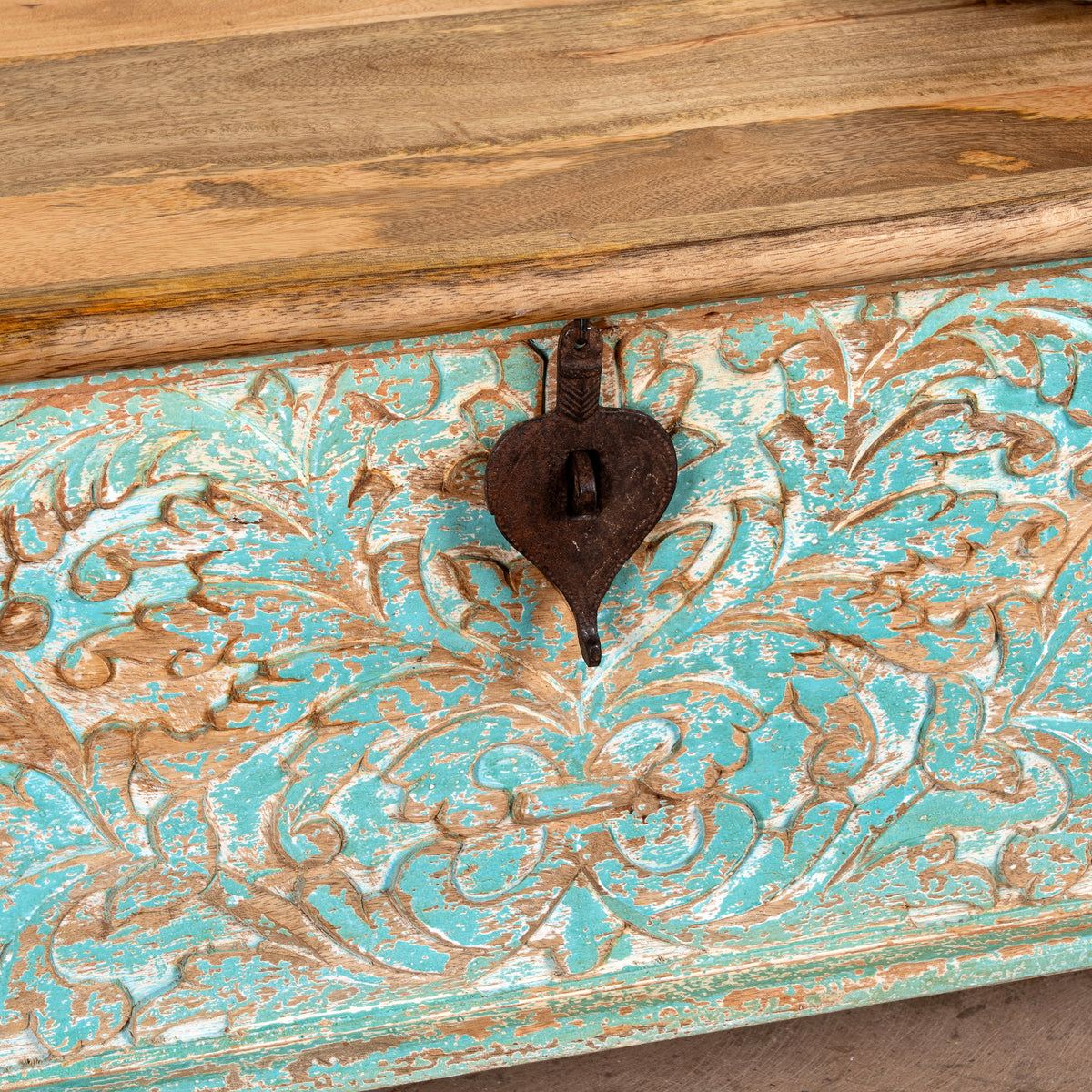 Close up image of a Neysa hand carved mango wood chest coffee table with turquoise floral design, natural wood top and iron lock, 90cm wide