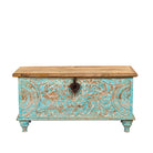 White background image of a Neysa hand carved mango wood chest coffee table with turquoise floral design, natural wood top and iron lock, 90cm wide