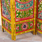 Close up image of a hand carved and hand painted mango wood room divider with colourful floral Indian motifs and folding panels.