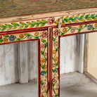 Close up image of a Nikhil hand painted reclaimed wood display cabinet with colourful floral design and four open display sections 120cm