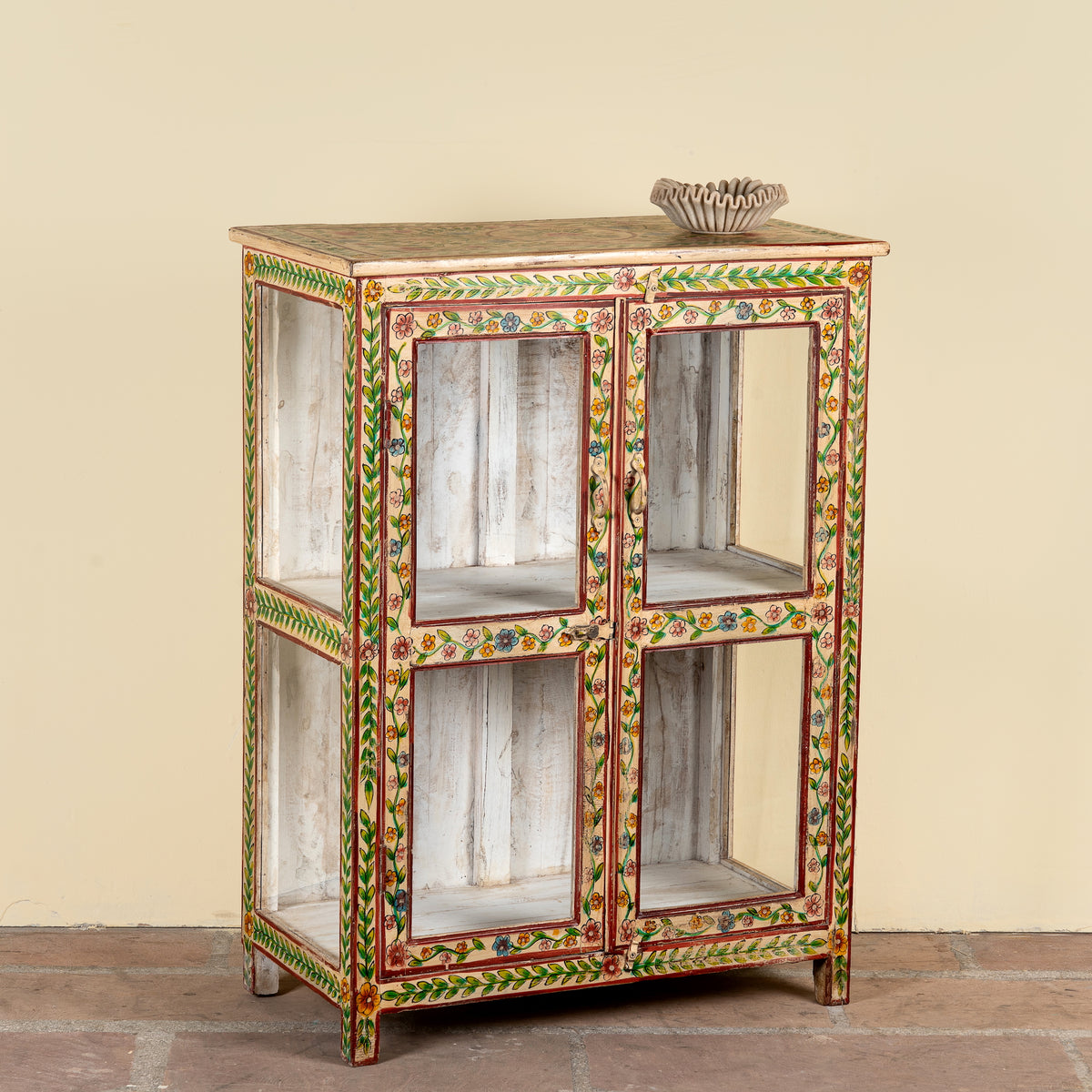 Side angle image of a Nikhil hand painted reclaimed wood display cabinet with colourful floral design and four open display sections 120cm