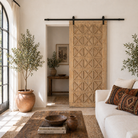 Lifestyle image of a vintage wall panel Nila, handcrafted reclaimed wood Indian door with geometric carvings, 100 × 5 × 220 cm.
