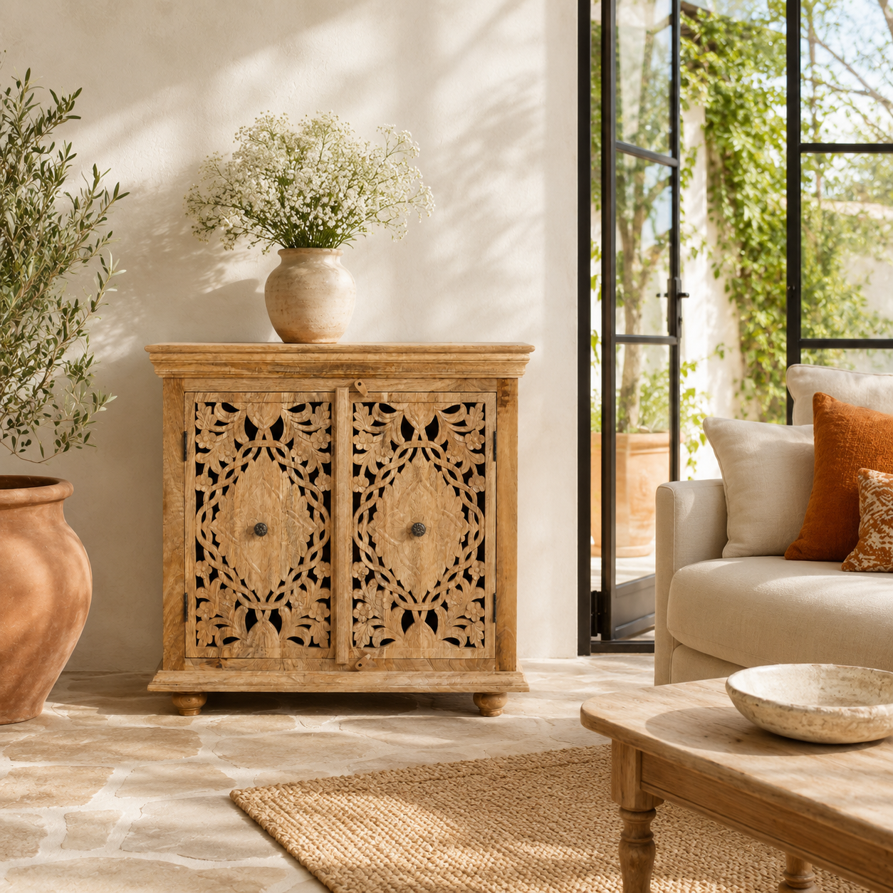 Lifestyle image of a Nilay hand carved mango wood cabinet with floral carved doors 90x90cm