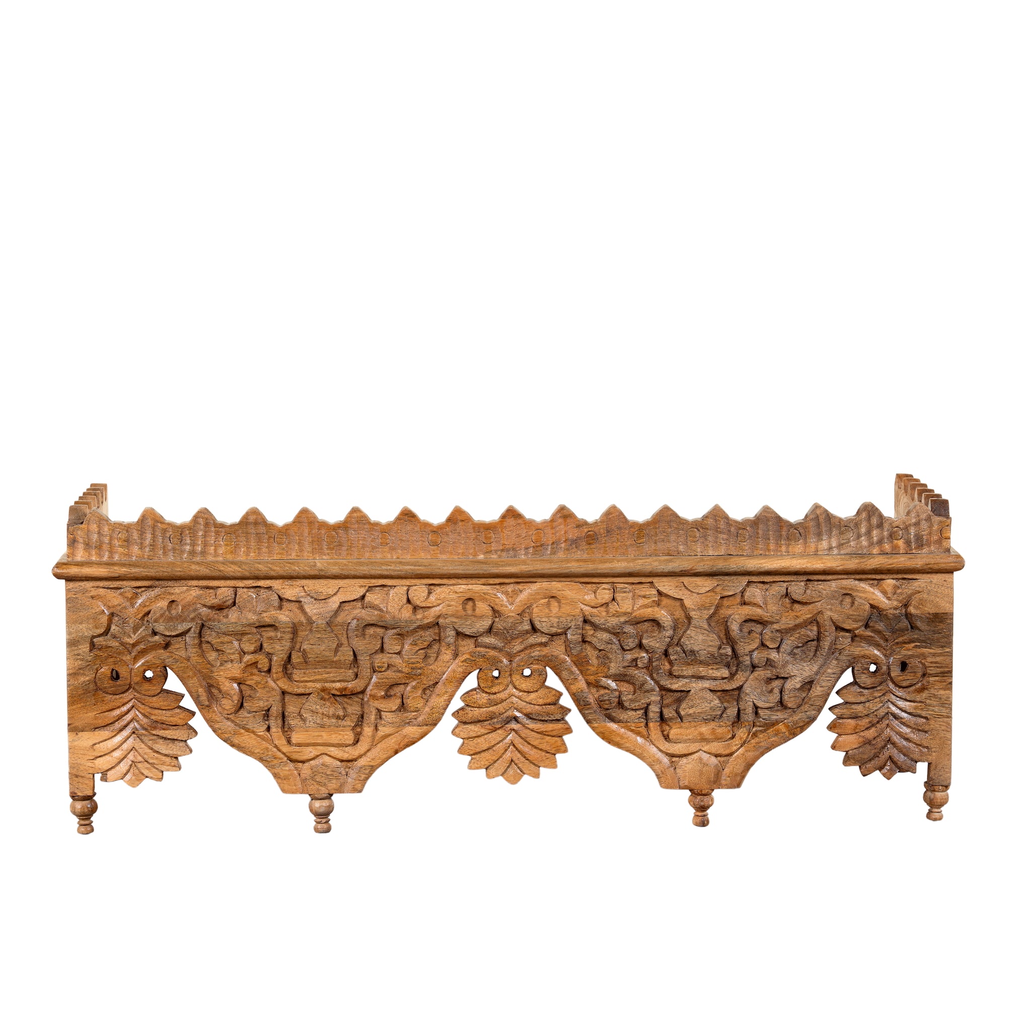 White background image of a Nirvay hand carved mango wood wall shelf with floral carvings and decorative hanging leaf ornaments 90cm