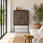 Lifestyle image of a black wooden cabinet with handcrafted copper inlays and nickel-plated metal base—an artisanal furniture piece with a refined minimalistic style.