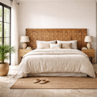 Lifestyle image of a Okha antique Indian teak door repurposed as a decorative wall panel or old door headboard, featuring original hand-carved detailing and a naturally aged finish—an authentic piece of old Indian door furniture.