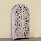 Side angle image of a hand-carved mango wood wardrobe, a statement piece of bedroom furniture ideal for a bohemian interior.