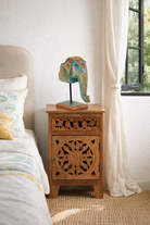 Lifestyle imagination of a hand-painted decorative wooden elephant head on iron stand with floral Indian folk art – ideal for Indian and vintage home accessories.