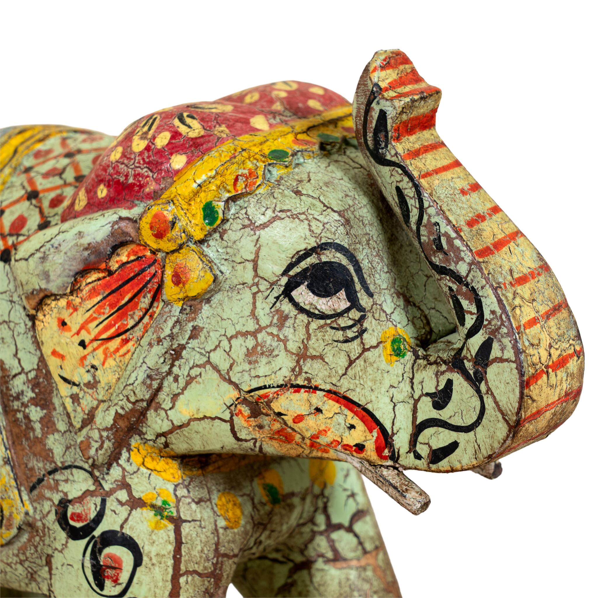 Close up image of a green hand‑painted wooden elephant decoration with colorful folk art motifs, a unique Indian home accessory and vintage home decor accent.