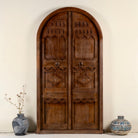 Front view image of an arched Moroccan-style door with frame made from reclaimed wood, featuring hand-carved details and a natural aged finish, suitable for wall décor or inbuilt installation.