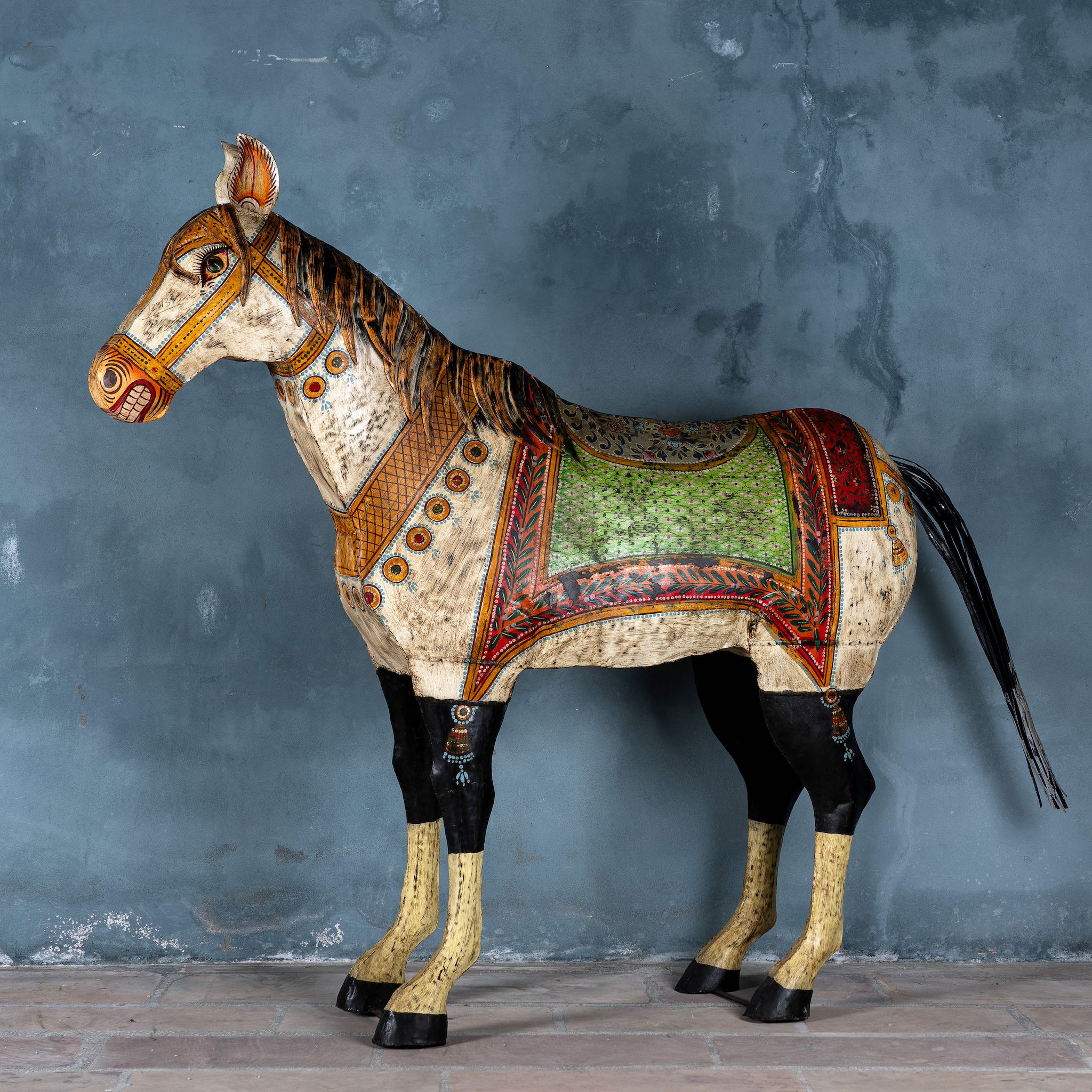 Large hand-painted decorative horse sculpture made of sheet metal in vibrant Rajasthani style, featuring intricate floral and geometric patterns in red, green, and black. Ideal for enhancing entrance areas, restaurant lobbies, hotel receptions, or luxury interior spaces.