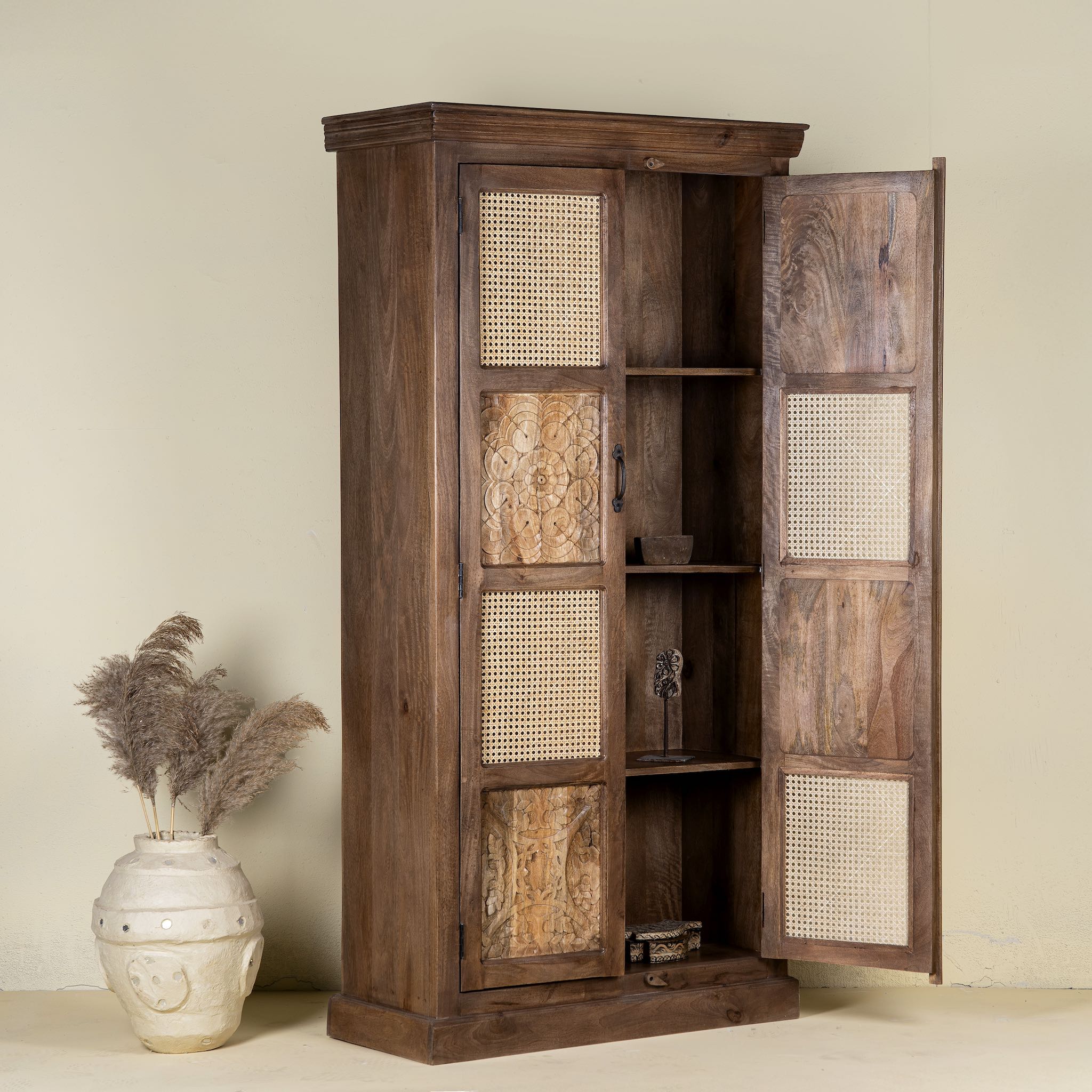 Open door  image of a tall mango wood furniture cabinet with hand-carved details and woven rattan doors, artisan rattan furniture, 90 × 40 × 180 cm.