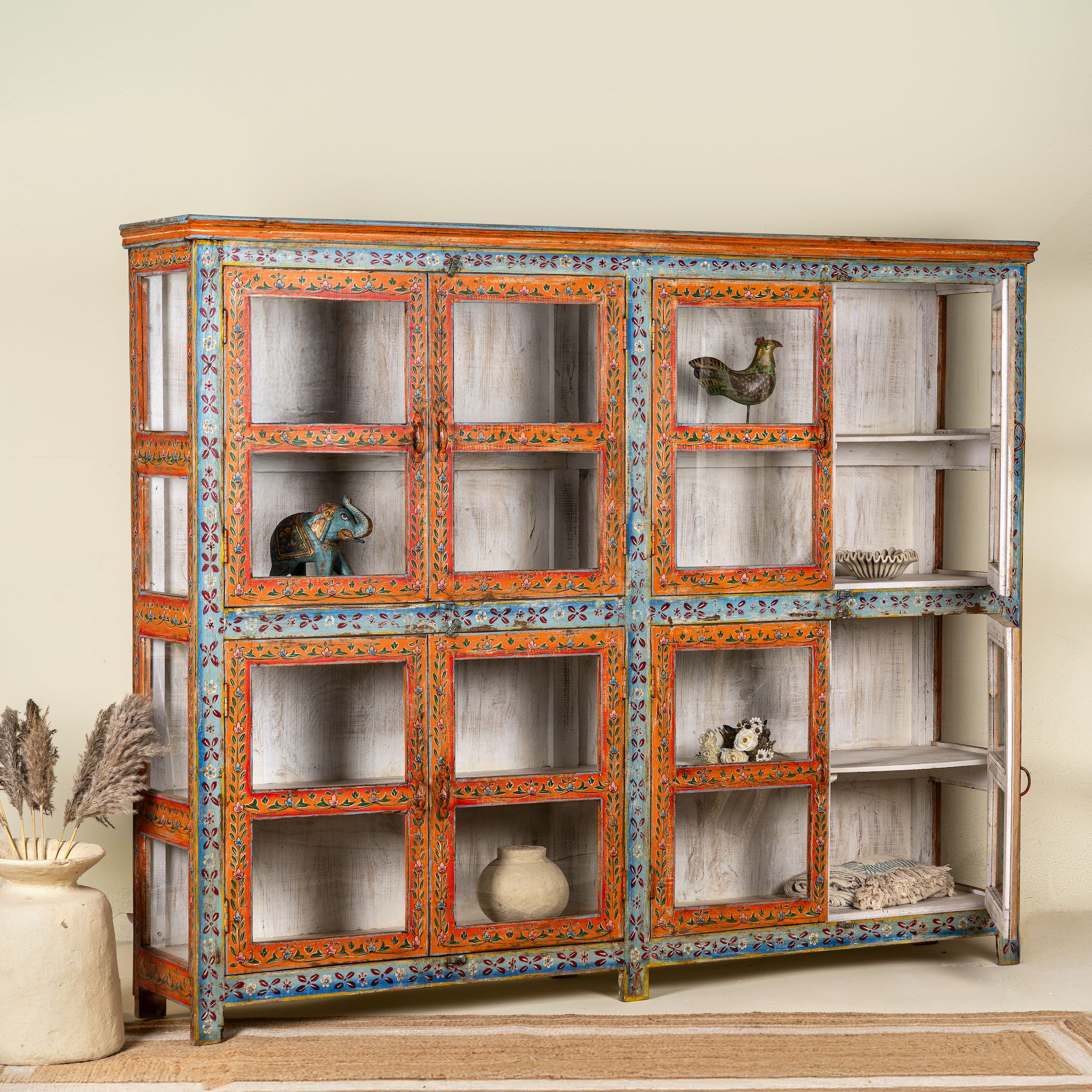 Open door image of a hand-painted reclaimed wood showcase cabinet with Ibiza-style motifs, glass-panelled doors, unique wooden furniture for living room, 213 × 40 × 170 cm.
