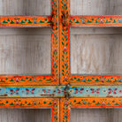 Close up image of a hand-painted reclaimed wood showcase cabinet with Ibiza-style motifs, glass-panelled doors, unique wooden furniture for living room, 213 × 40 × 170 cm.