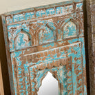 Close up image of a hand-carved small wooden wall mirrors Pranith with arched Indian jharokha designs, available in various vintage finishes. A unique Indian decoration and vintage home accessory for layered vintage home decor.