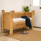 Lifestyle imagination of a reclaimed teak wood bench with horse-head carvings and hidden storage; sustainable double-seater with cushion, 150 × 93 × 77 cm.