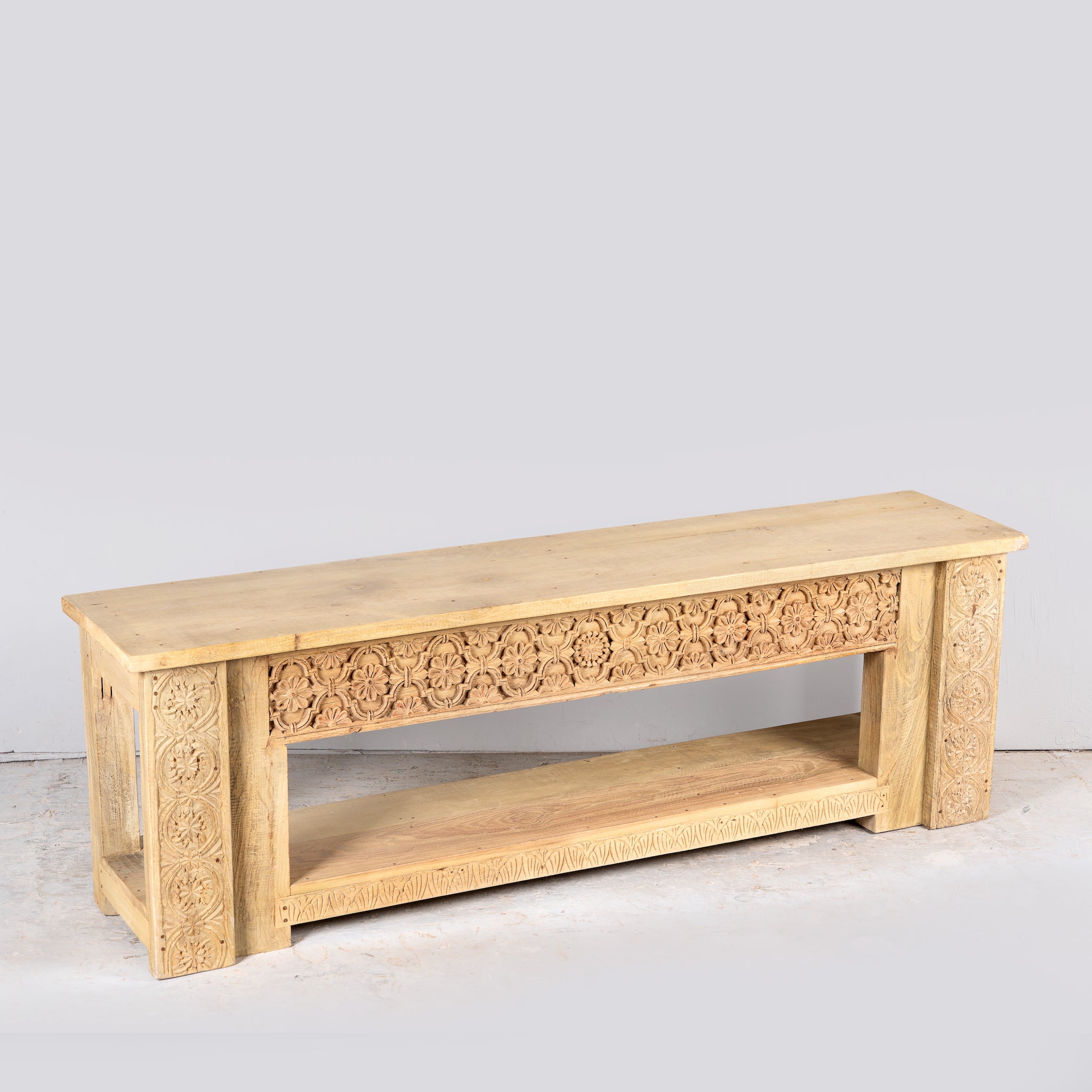 Side angle image of a Purna reclaimed teak wood bench with hand carved Indian house elements and lower shelf 160cm
