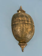Antique-style hand-stamped iron wall lamp with brass finish, featuring intricate perforated detailing and vintage ornamental shape.