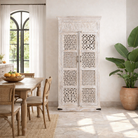 Lifestyle image of a hand-carved mango wood wardrobe with whitewashed finish, bedroom furniture wooden wardrobe with floral and geometric lattice doors, 90 × 190 × 40 cm.