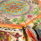 Close up image of a hand-painted wooden  side table in the shape of a ram with curved horns, featuring colourful Indian folk art patterns, ideal for vintage and India-inspired home accessories.