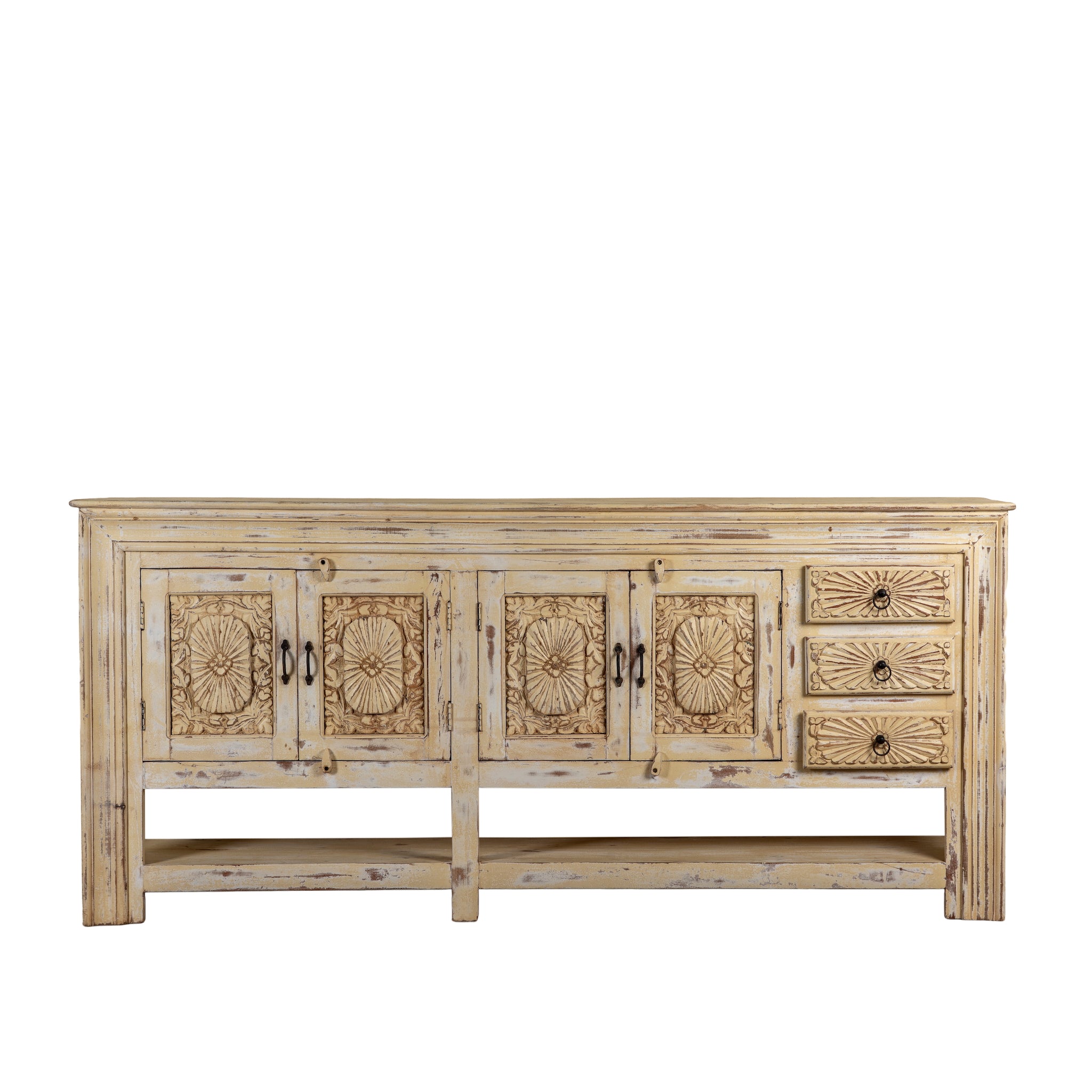 White background image of a Ranjit reclaimed wood vintage console table with cream distressed finish, carved doors, three drawers and open lower shelf. 
