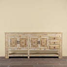 Ranjit reclaimed wood vintage console table with cream distressed finish, carved doors, three drawers and open lower shelf.