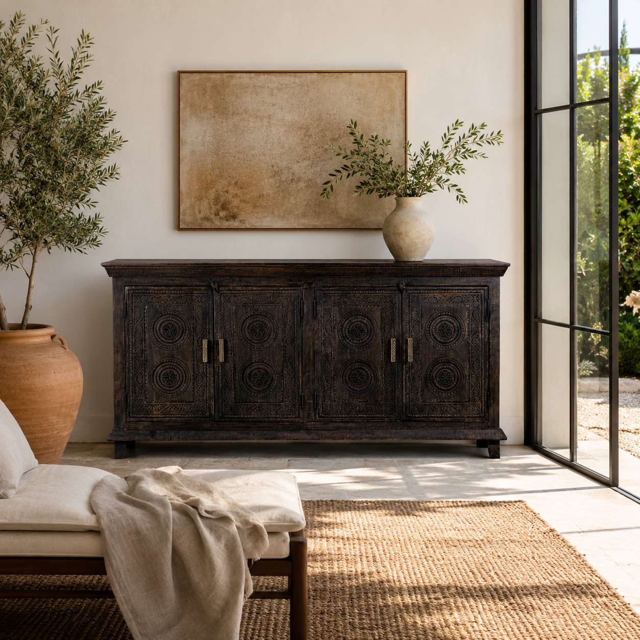 Lifestyle image of a handcrafted wood carved sideboard in black mango wood with four doors, versatile for bedroom furniture or living spaces, 180 × 40 × 90 cm.