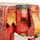 Close up image of a red hand-painted wooden elephant-shaped side table with Indian folk art motifs and floral details, perfect for vintage or global home decor.