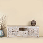 Old door cabinet with hand-carved antique teak panels, whitewashed mango wood body, drawers and shelf, 180 × 40 × 70 cm.