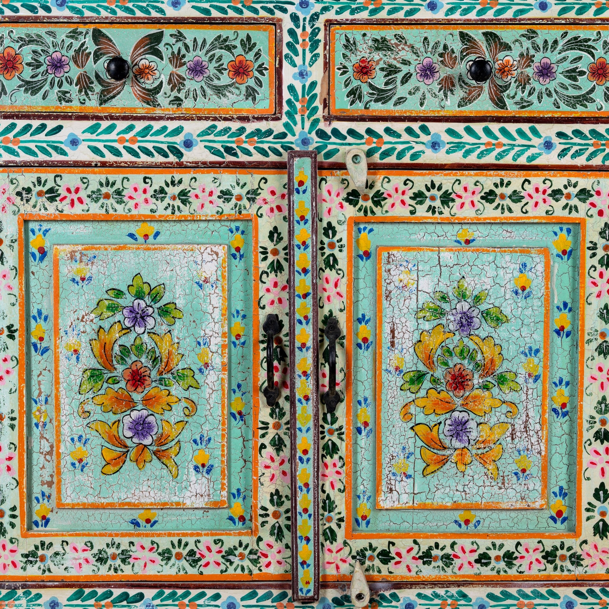 Close up image of a hand painted green Indian cabinet made from recycled wood with floral motifs, 2 drawers and 2 compartments, 90 × 90 × 40 cm.