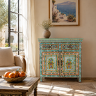 Lifestyle image of a hand painted green Indian cabinet made from recycled wood with floral motifs, 2 drawers and 2 compartments, 90 × 90 × 40 cm.