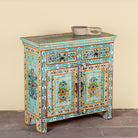 Side angle image of a hand painted green Indian cabinet made from recycled wood with floral motifs, 2 drawers and 2 compartments, 90 × 90 × 40 cm.