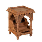 Side angle image of a handcrafted old teak wood home temple with carved details and drawer, ideal for religious items and Indian spiritual home accessories.
