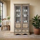Lifestyle image of a hand-painted display cabinet Ritesh made from recycled wood with glass doors – sustainable furniture featuring Sanskrit motifs and traditional Indian craftsmanship.