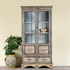 Lifestyle image of a hand-painted display cabinet Ritesh made from recycled wood with glass doors – sustainable furniture featuring Sanskrit motifs and traditional Indian craftsmanship.