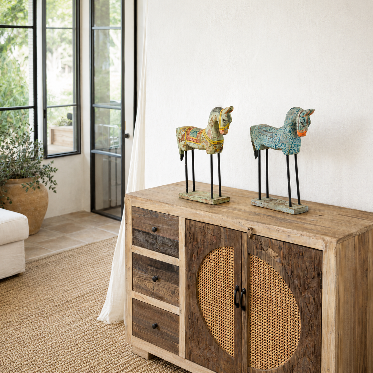 Lifestyle imagination of a of a hand-painted wooden horse sculptures on iron stands in assorted colours and designs. Unique Indian decor items, perfect for bohemian interiors and artisanal furniture displays.