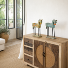 Lifestyle imagination of a of a hand-painted wooden horse sculptures on iron stands in assorted colours and designs. Unique Indian decor items, perfect for bohemian interiors and artisanal furniture displays.