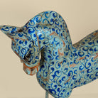 Close up image of a hand-painted wooden horse sculptures on iron stands in assorted colours and designs. Unique Indian decor items, perfect for bohemian interiors and artisanal furniture displays.