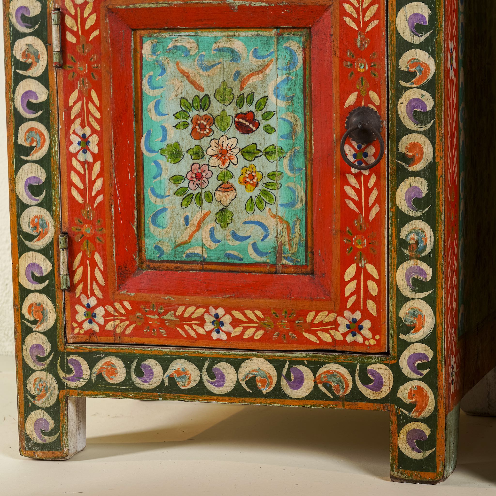 Close up image of a hand-painted bedside tables made from recycled wood – vintage night stands with carved mango wood furniture detailing and floral artistry.