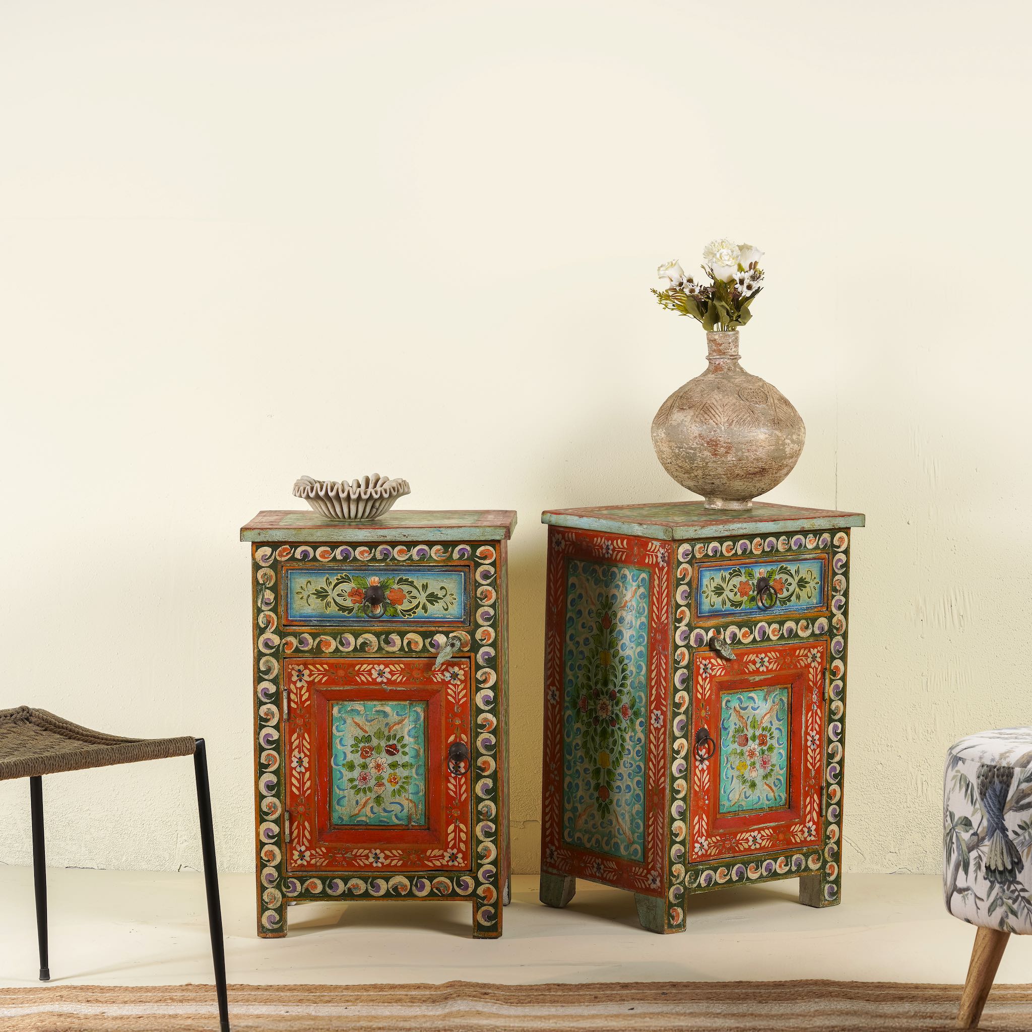 Side angle image of a hand-painted bedside tables made from recycled wood – vintage night stands with carved mango wood furniture detailing and floral artistry.