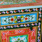 Close up image of a hand-painted bedside table made from recycled wood – vintage night stands with carved mango wood furniture detailing and floral artistry.