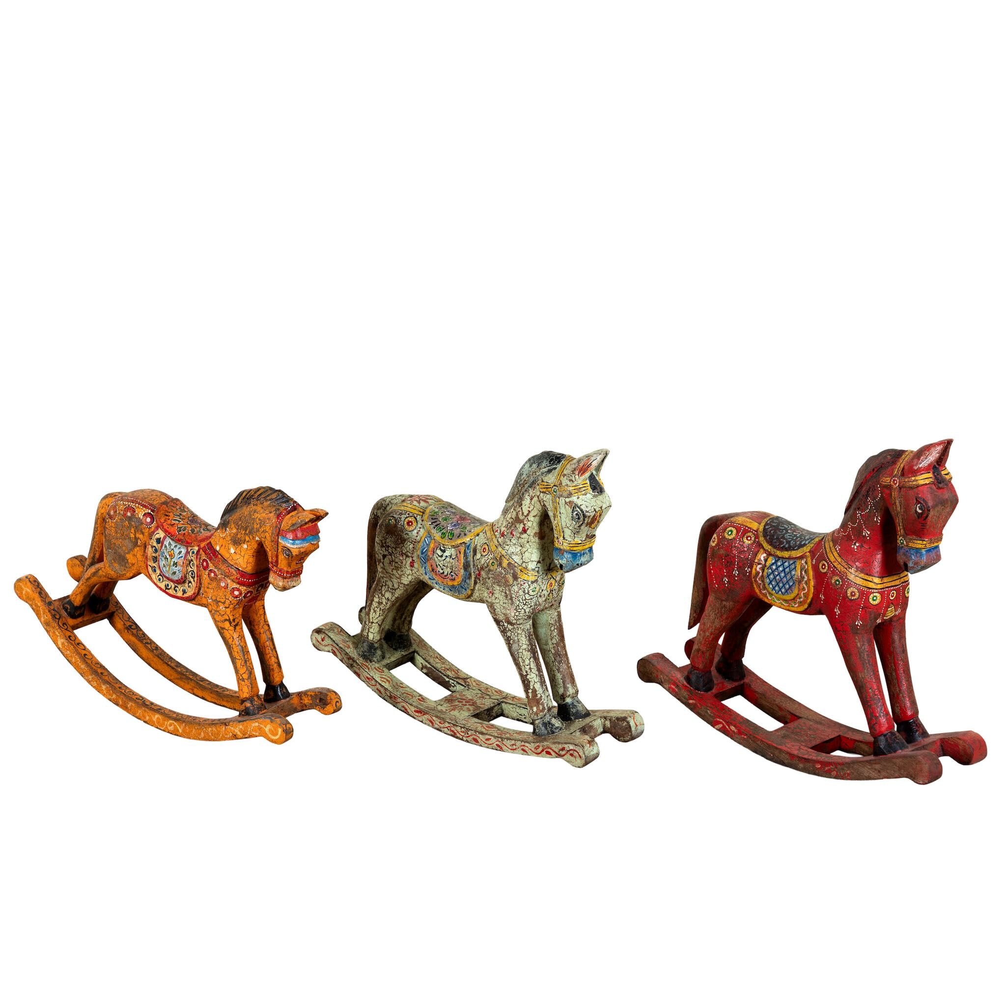 Colourful hand-painted wooden rocking horses with ornate saddle patterns, crafted in India. Unique bohemian interior décor accents made from solid wood, perfect for shelves or sideboards.
