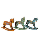 White background image of a colourful hand-painted wooden rocking horses with ornate saddle patterns, crafted in India. Unique bohemian interior décor accents made from solid wood, perfect for shelves or sideboards.
