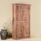 Side view of a carved acacia wood wardrobe with floral detailing and brass handles; artisanal acacia wood furniture, 100 × 40 × 180 cm.