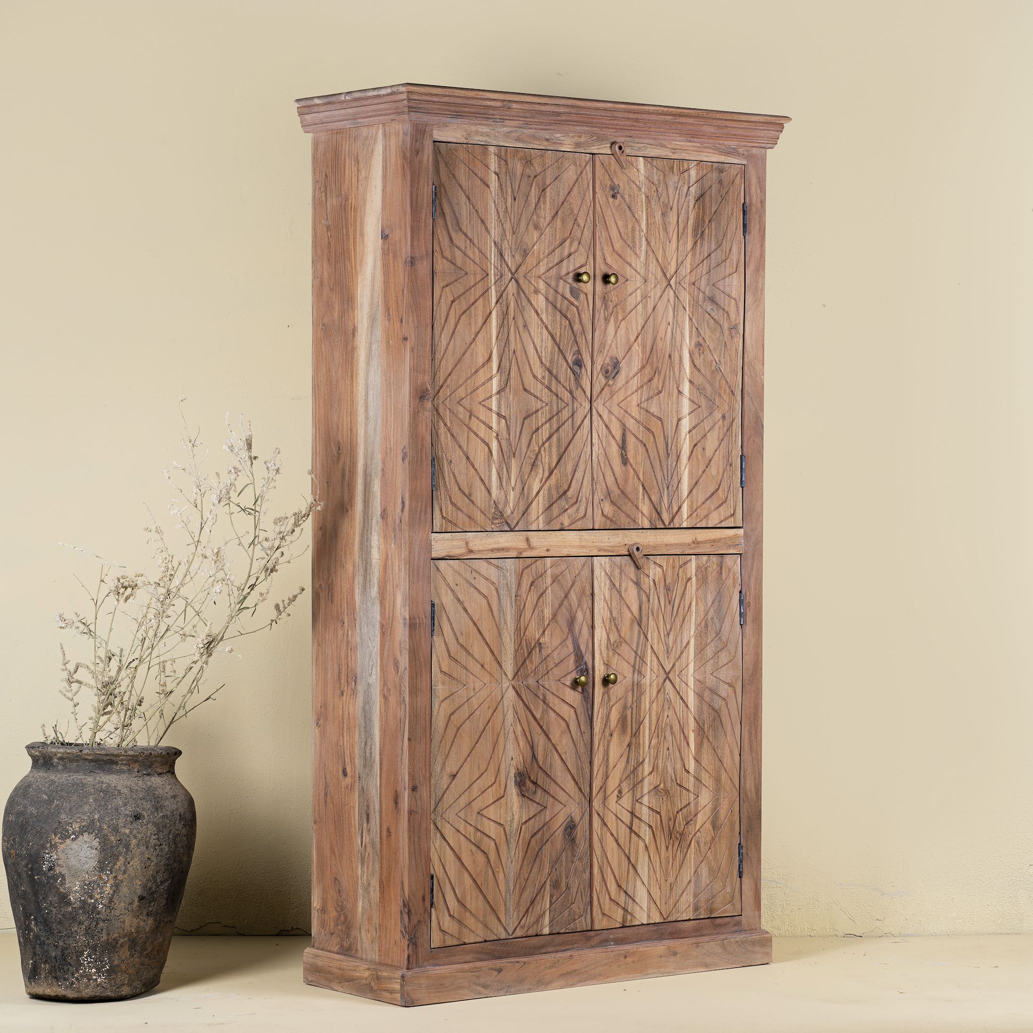 Side view of a carved acacia wood wardrobe with floral detailing and brass handles; artisanal acacia wood furniture, 100 × 40 × 180 cm.