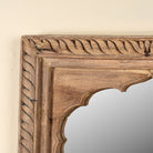 Close up image of a Ronavraj reclaimed teak wood mirror made from an old Indian window frame with carved border and shaped arch, 82x121cm