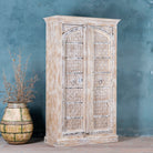 Side angle view of a cabinet made from an old teak door, featuring intricate hand-carved floral panels and a whitewashed finish — a striking piece with vintage charm and Ibiza style elegance.

